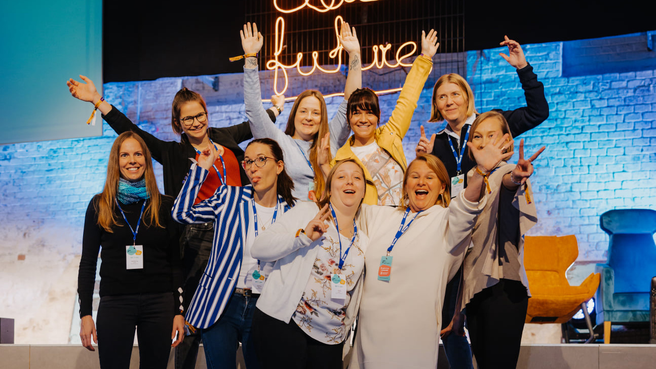 Eine Gruppe von EBCONT Kolleginnen steht auf einer Bühne beim Female Future Festival, lächelt und macht spielerische Gesten.